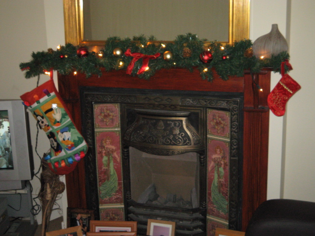 fireplace decorated with stockings and stocking beside the christmas tree