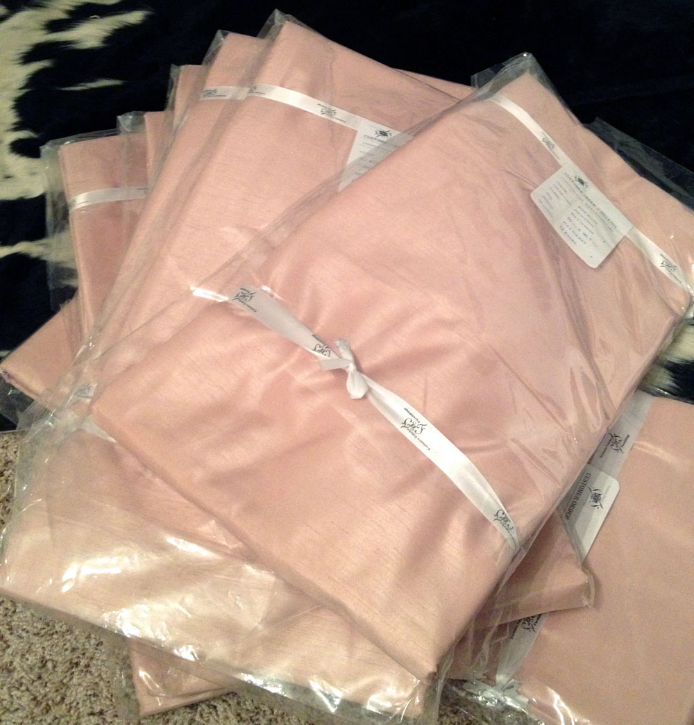 three sheets of cloth wrapped in pink paper