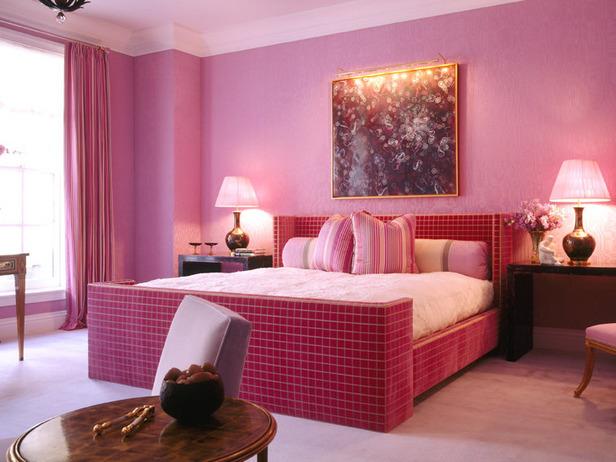 a bedroom that has pink walls and furniture