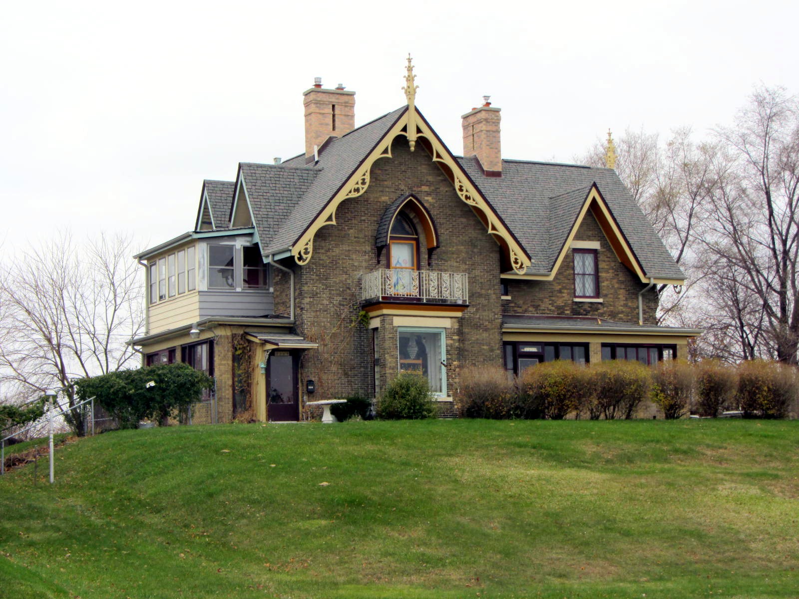 a large house sitting on top of a lush green hillside