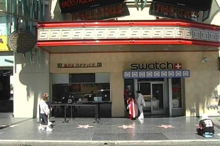 a movie theater with two people walking past