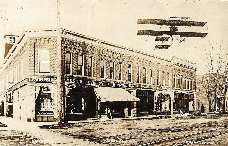 the plane is flying over a town street
