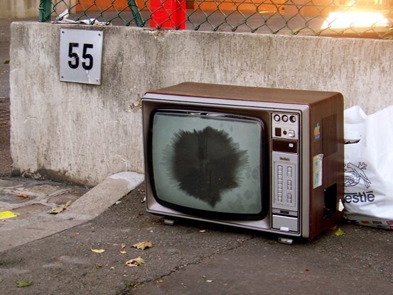 an old tv with an object on the ground