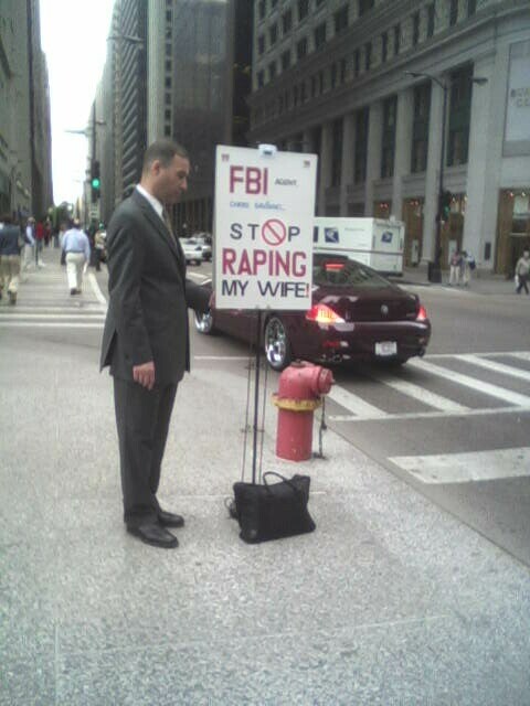 a man in a suit is standing beside a traffic signal and a red hydrant
