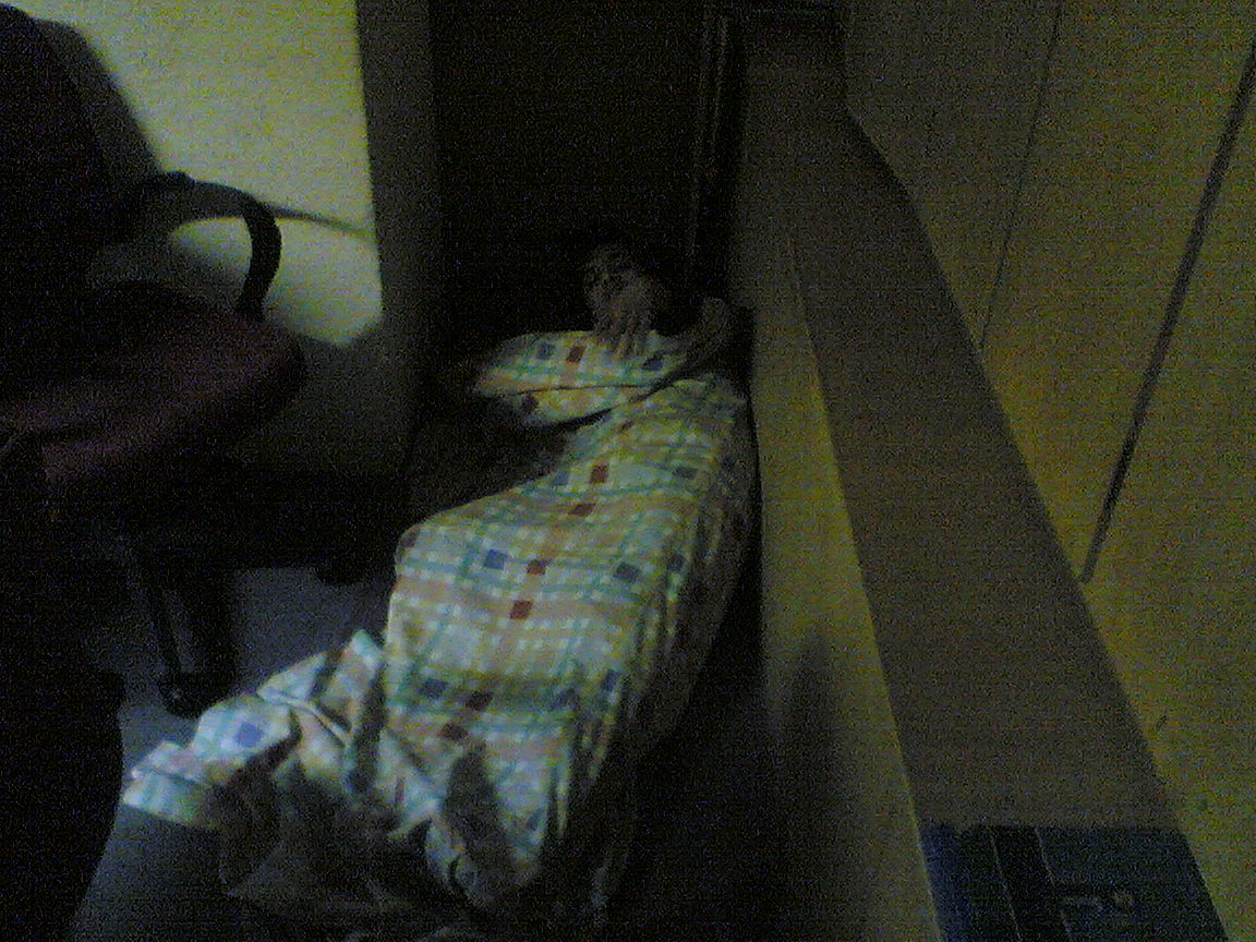 the child is wrapped in a blanket while sleeping on the bed
