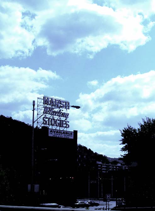 a tall sign with various lettering that is in the sky