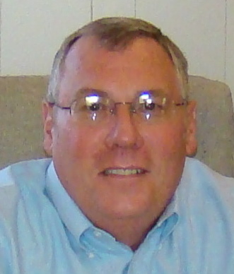 a man sitting on the couch wearing a blue shirt