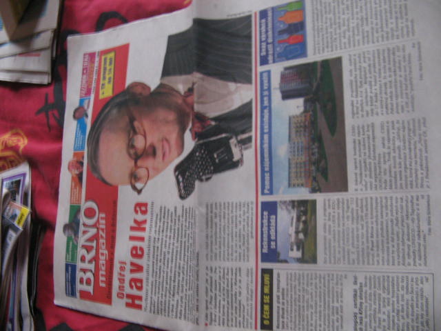 a newspaper paper that has a man wearing glasses