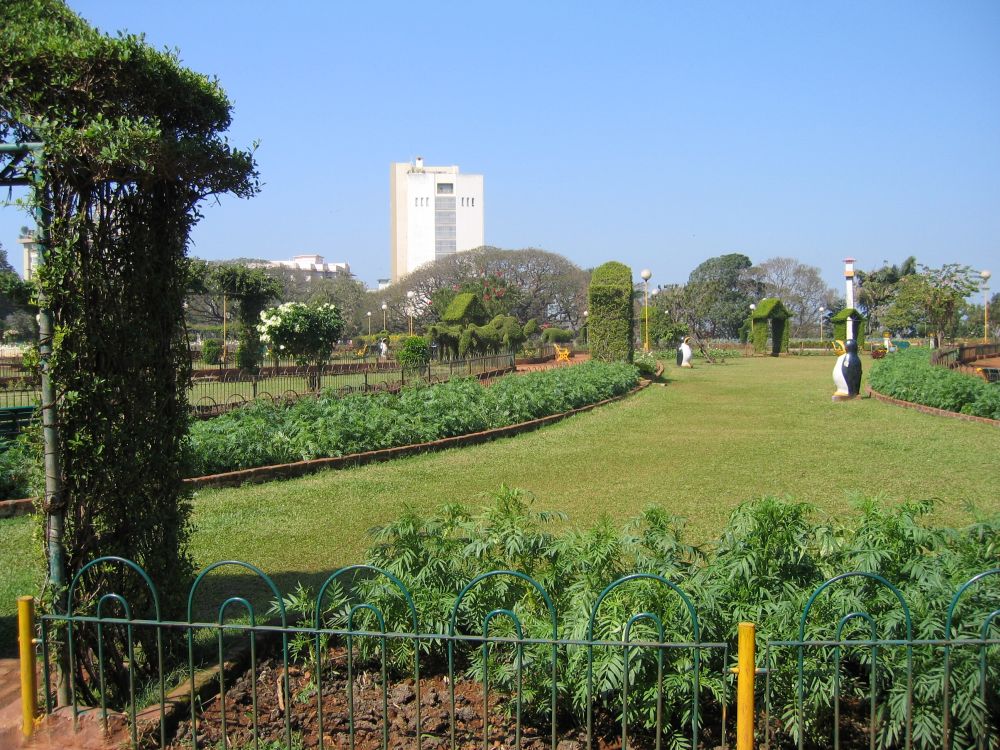 a large green field with people on it next to buildings