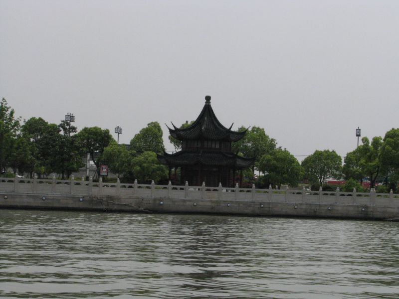 the building near the water is on the right side of the fence