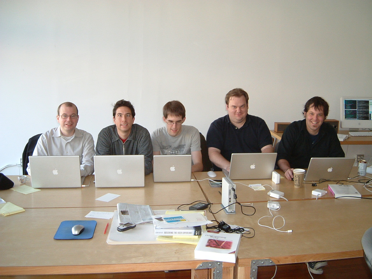 there are a group of men on a long table with laptops