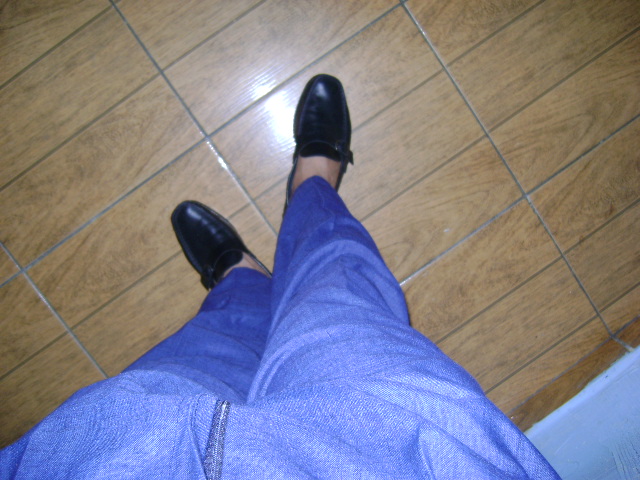 a man is standing with his legs crossed with blue pants