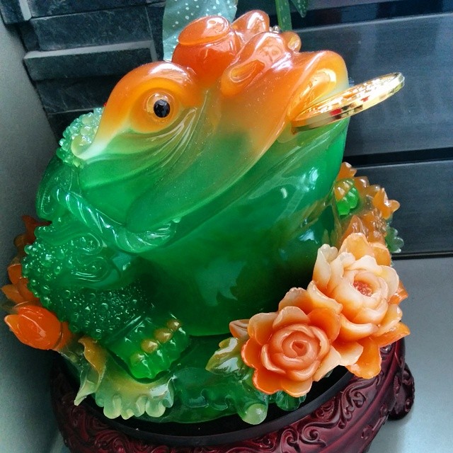 a glass frog sculpture sitting on top of a shelf