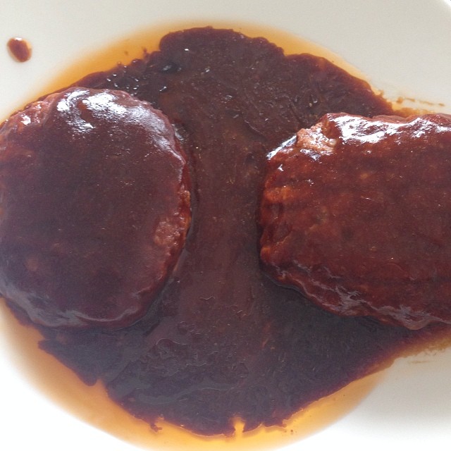two hamburger patties covered with ketchup in a bowl