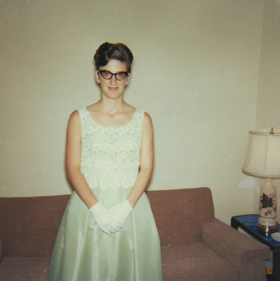 a woman wearing gloves stands by a couch