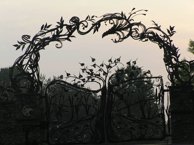 large black wrought iron gate with a clock