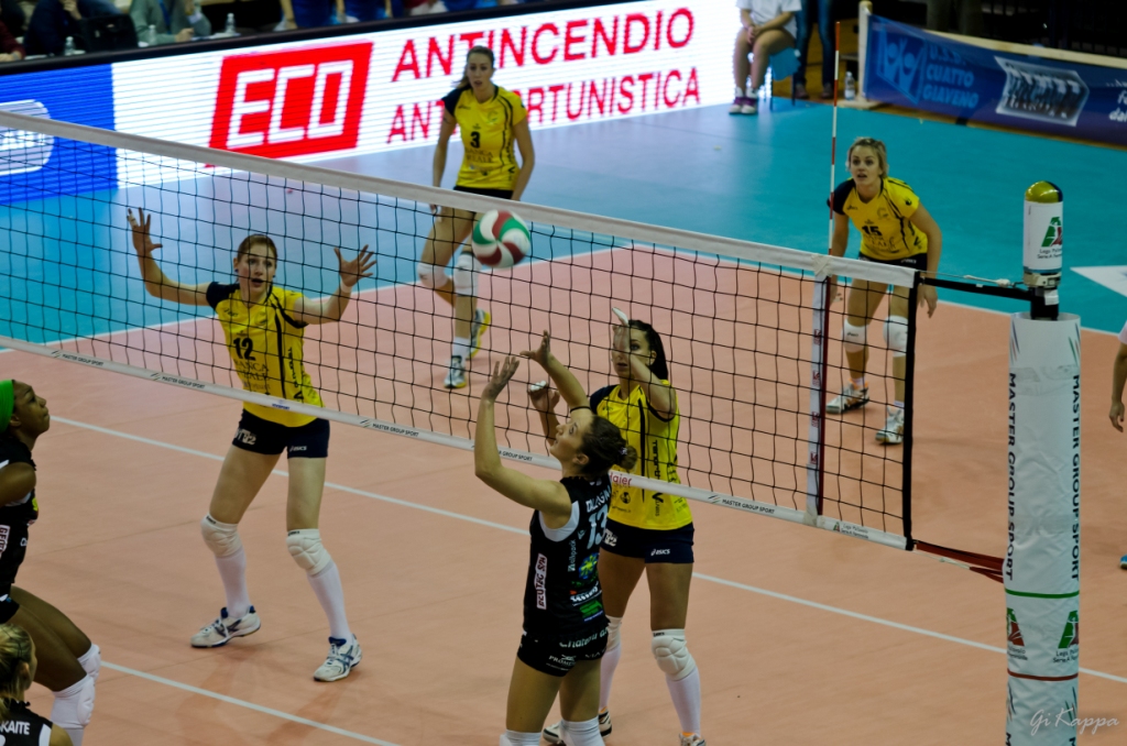 group of women playing volleyball during a match
