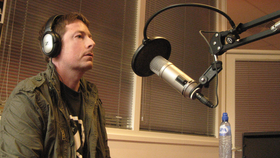 a man sits in a radio microphone and listens to music