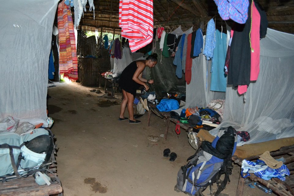 a person is bending over by an outdoor camping area