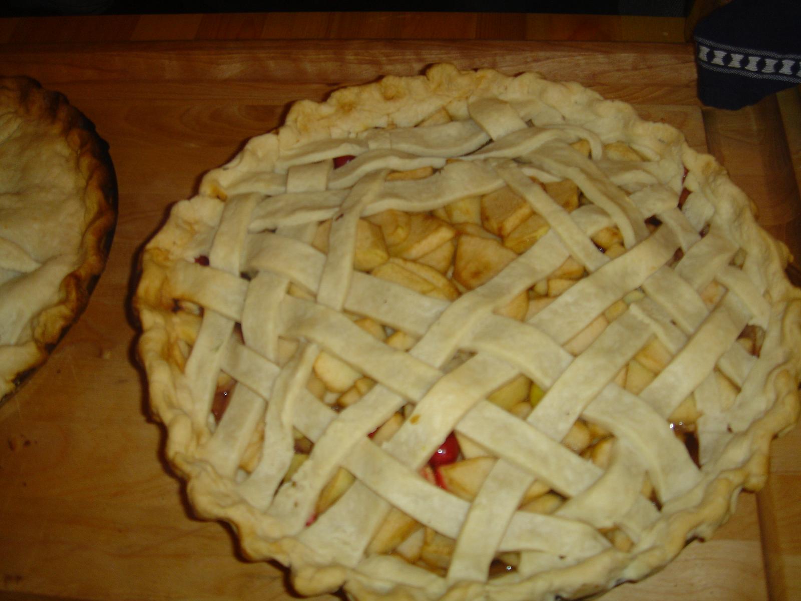 an apple pie with latticed crust on a  board