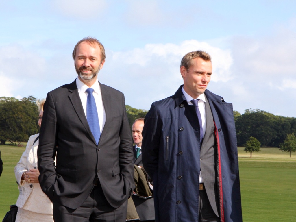 two men in suits and ties walking on the field