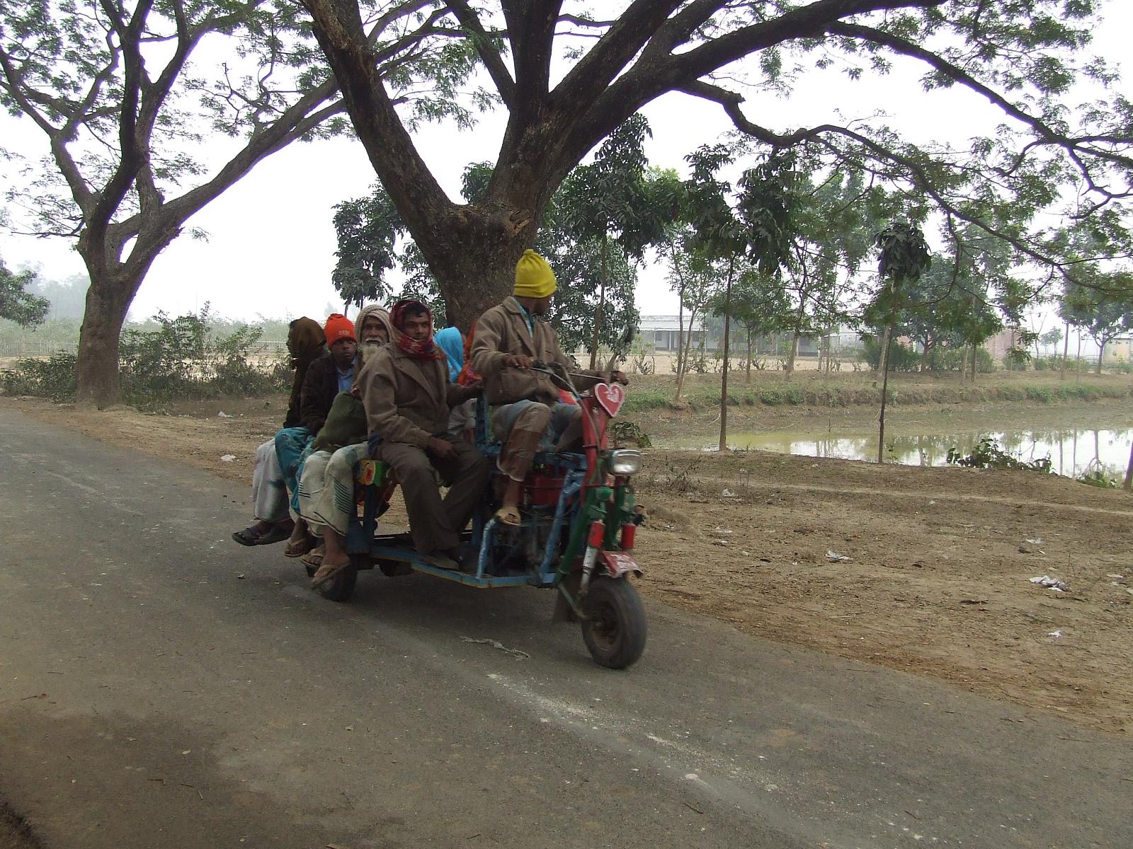 people riding in the back of a motorcycle on the side of the road