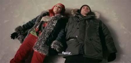 a couple wearing winter clothes lying in snow