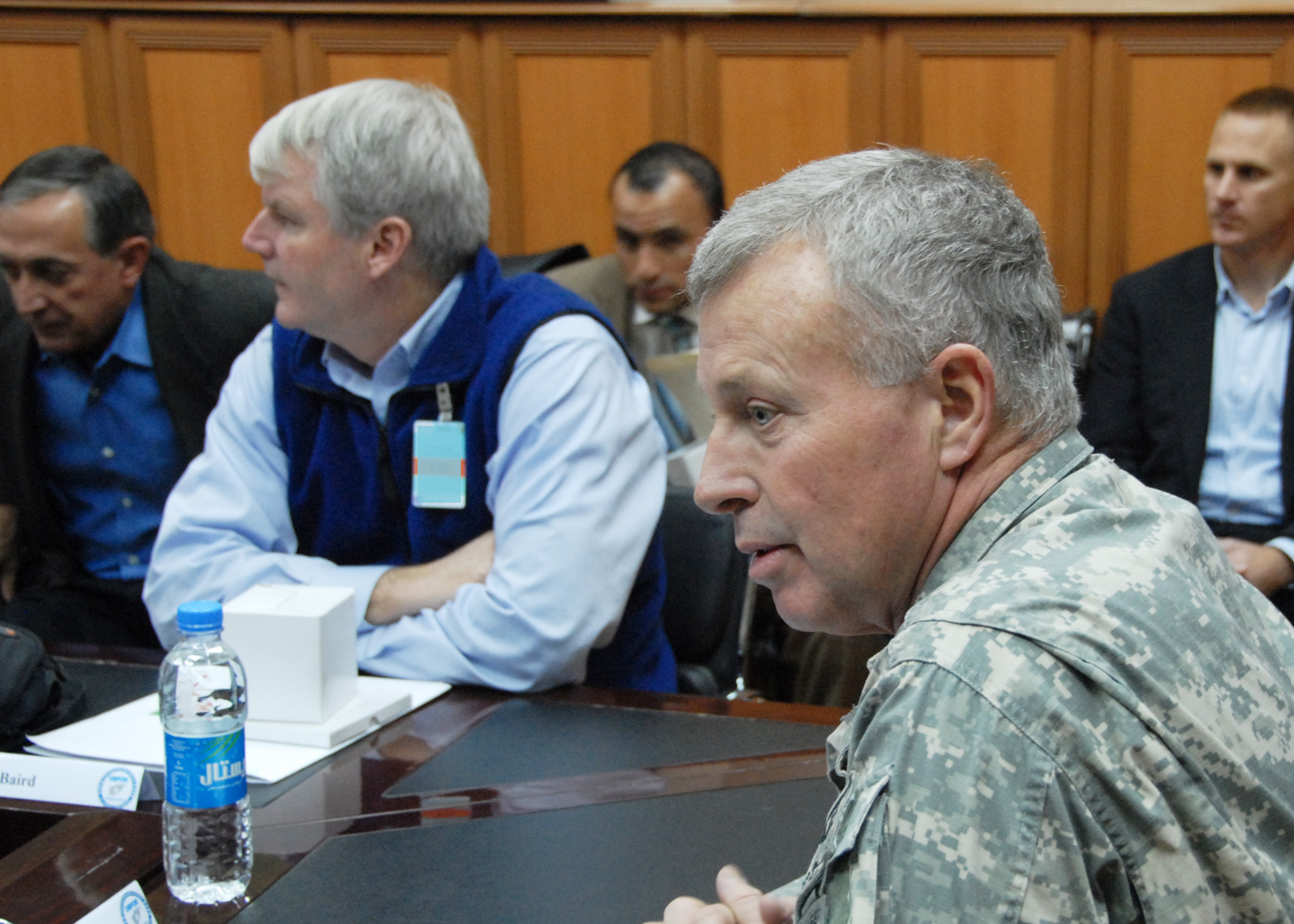 a military man is sitting at a conference table