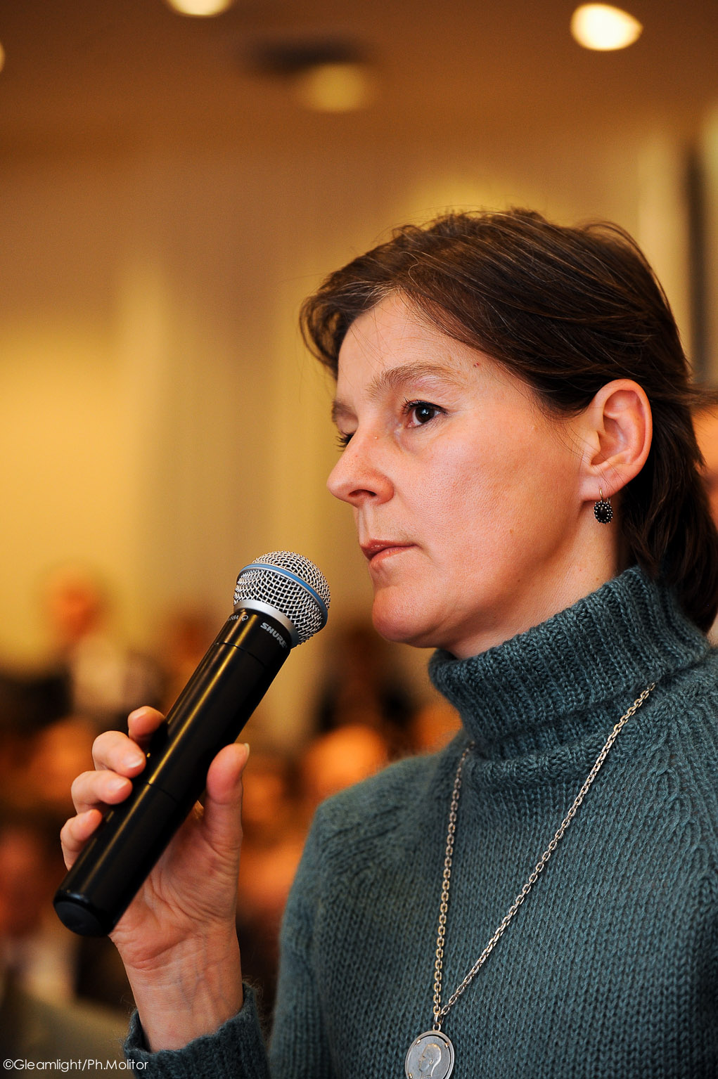 a woman holding a microphone while listening to someone