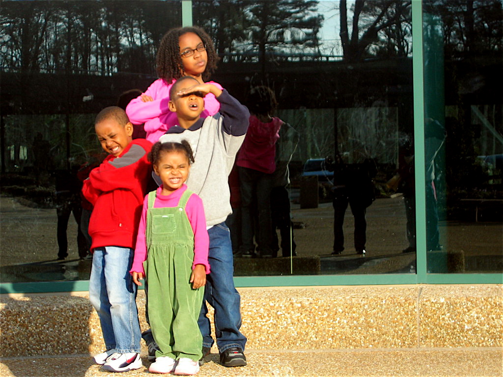a family stands outside the entrance of a glass building