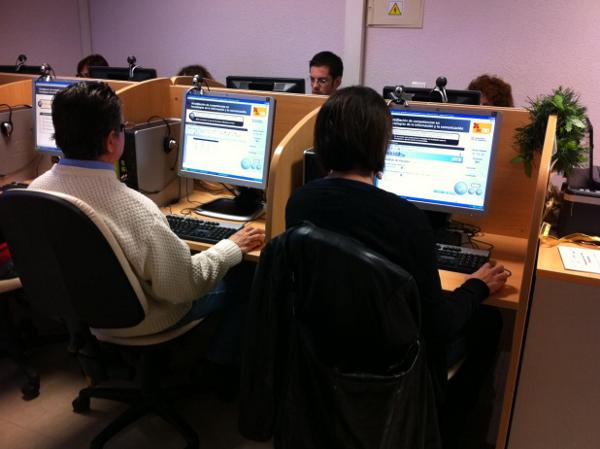a person working on two computer screens in a cubicle