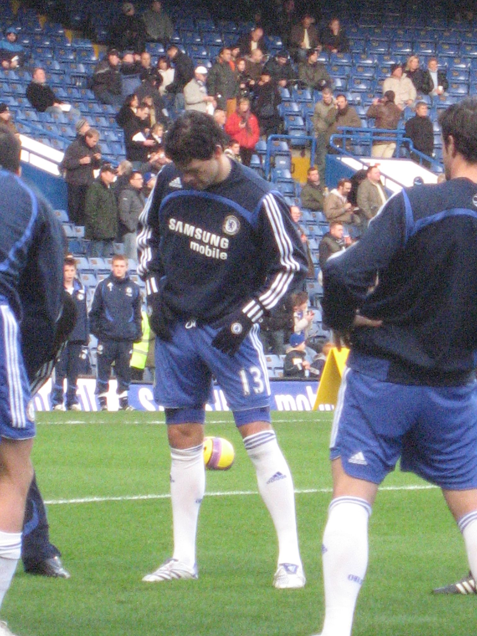 soccer players are standing on the grass in front of a crowd