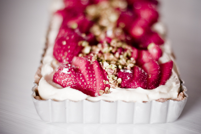 sliced strawberries are in a white tart dish