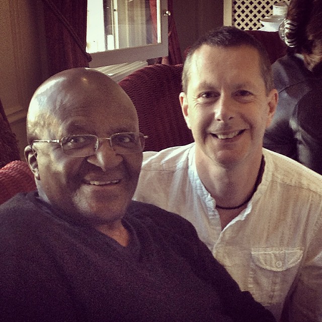 two men in shirt and glasses smiling at camera