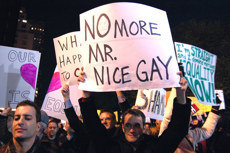 group of protestors holding signs in the street at night