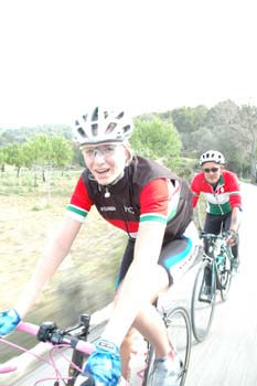 two bicyclists riding on the road while laughing