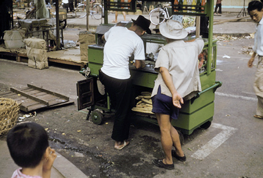 a man with several men working at a small stall