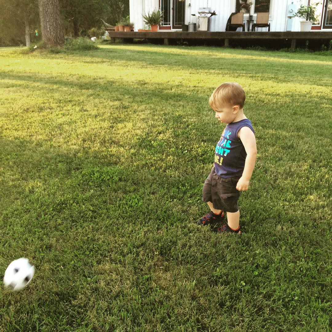 the little boy is playing with the ball