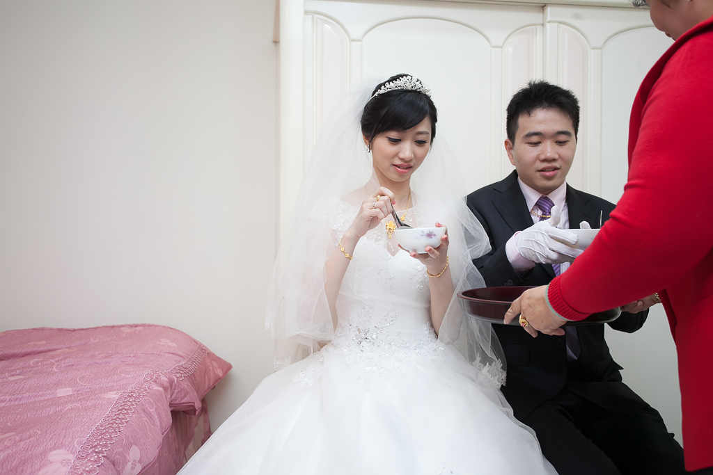 bride and groom kneeling on a bed during ceremony
