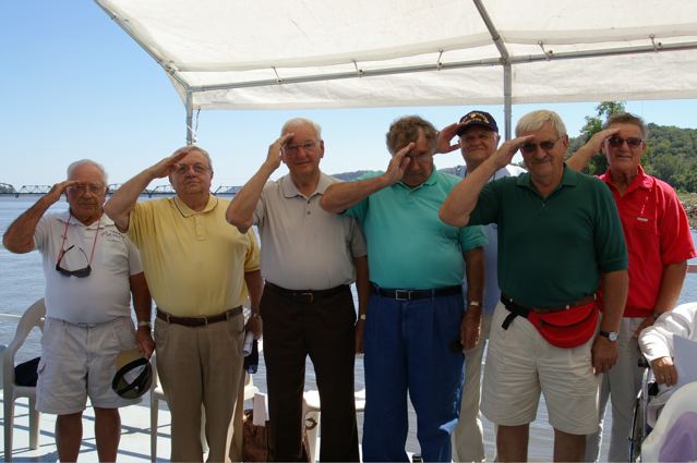 a group of men standing around each other on a boat