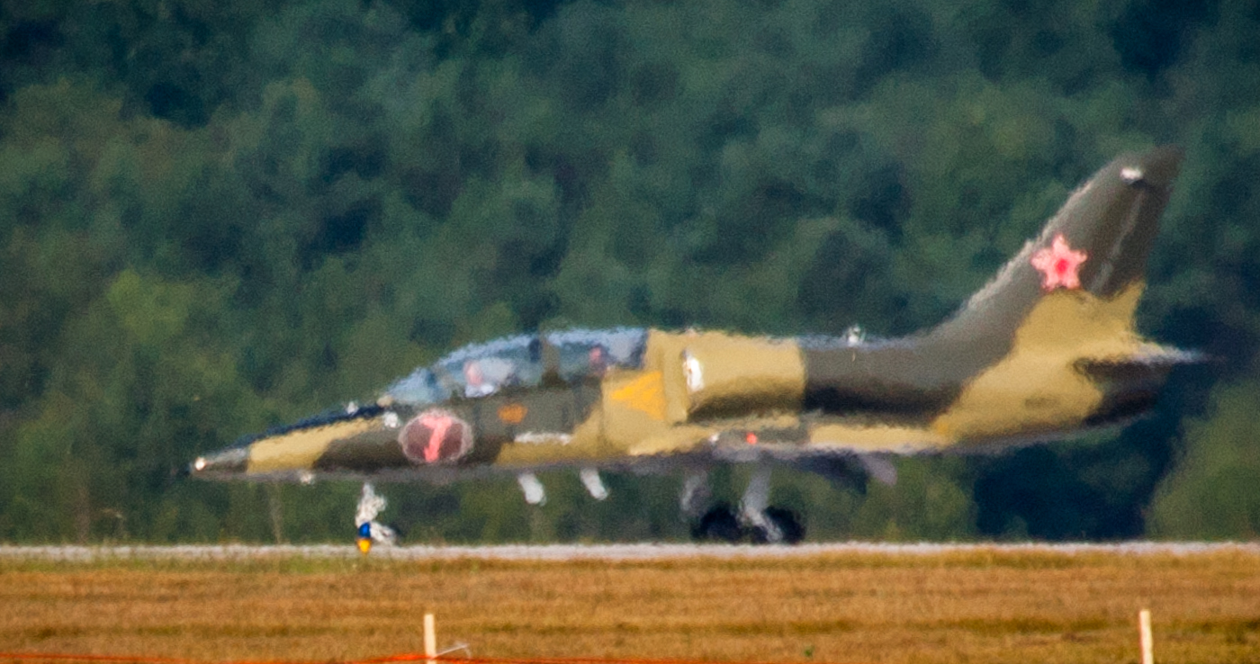 a military style jet takes off from an airport runway