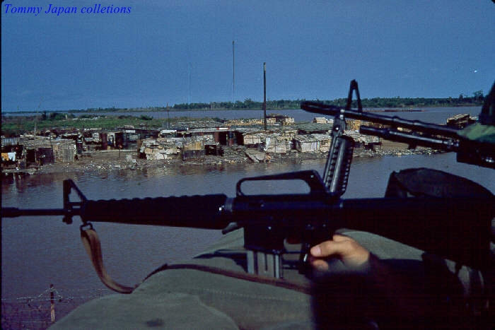 a person holding a machine gun on top of a boat