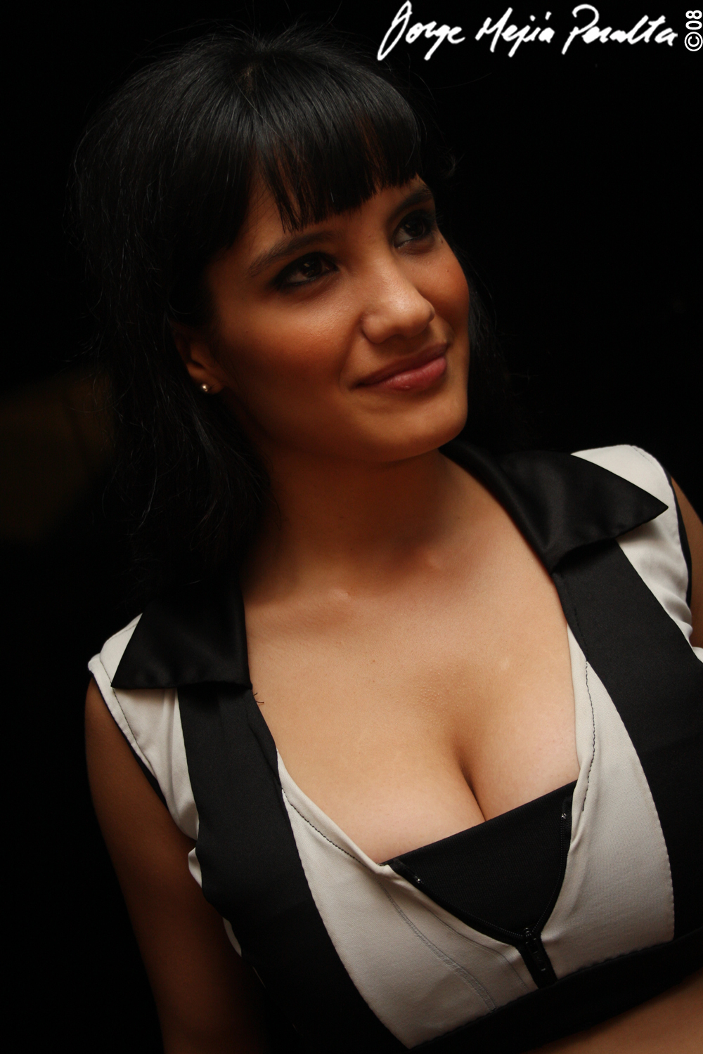 a smiling woman with very big  in a white and black dress