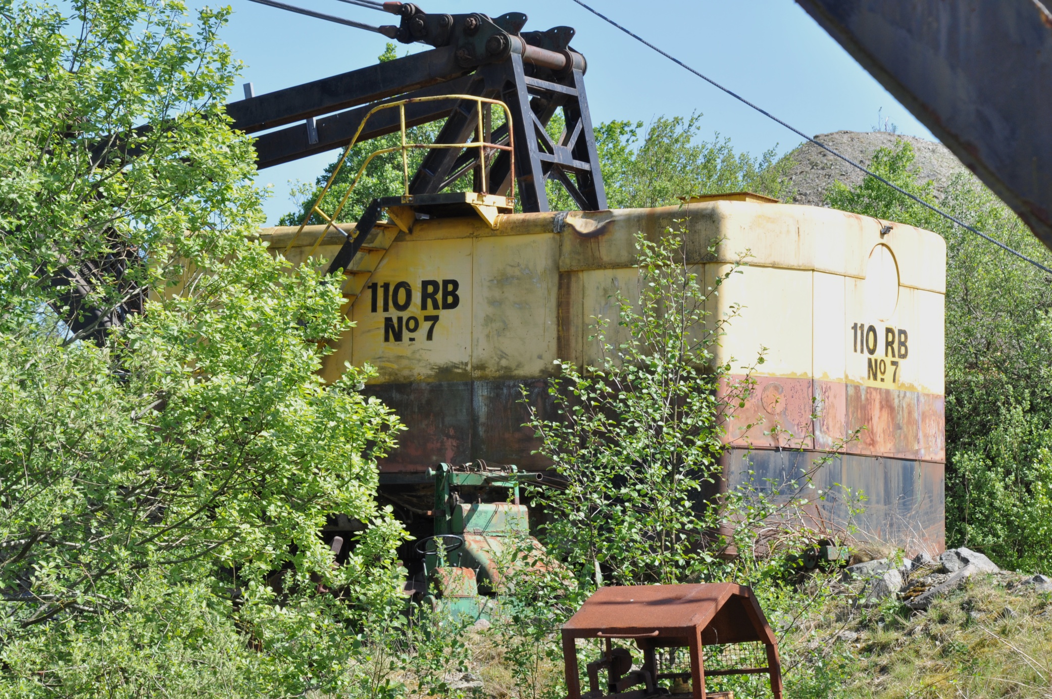 a large old abandoned train car sits in the woods