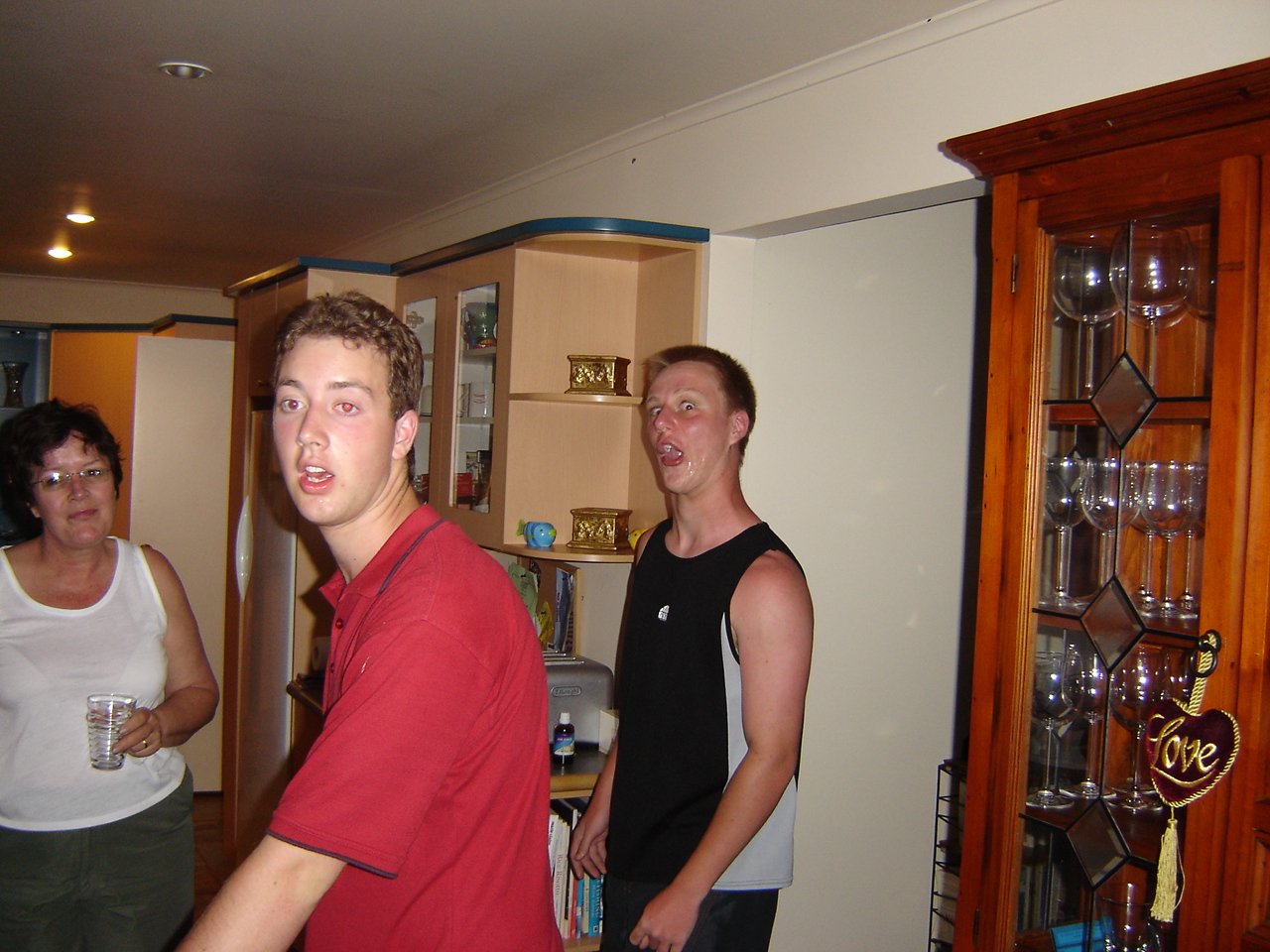 three men and one woman are standing in a kitchen