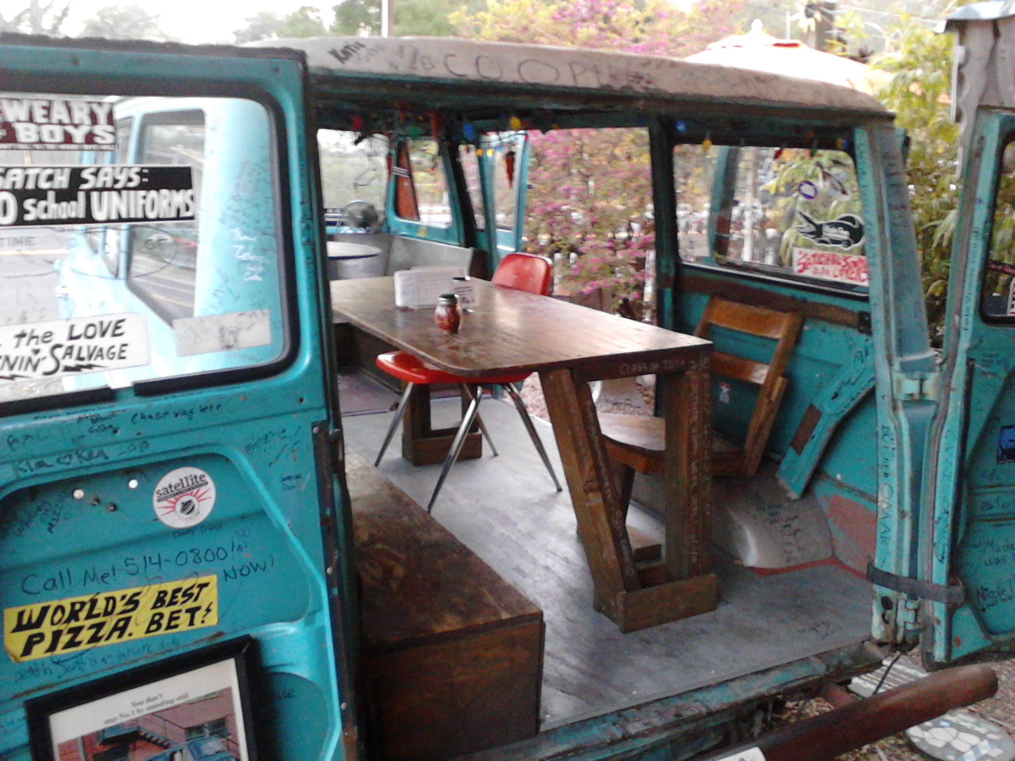 small blue truck is full of wooden furniture