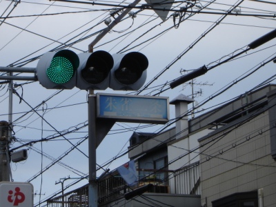 an electric pole and traffic light with many wires in the background