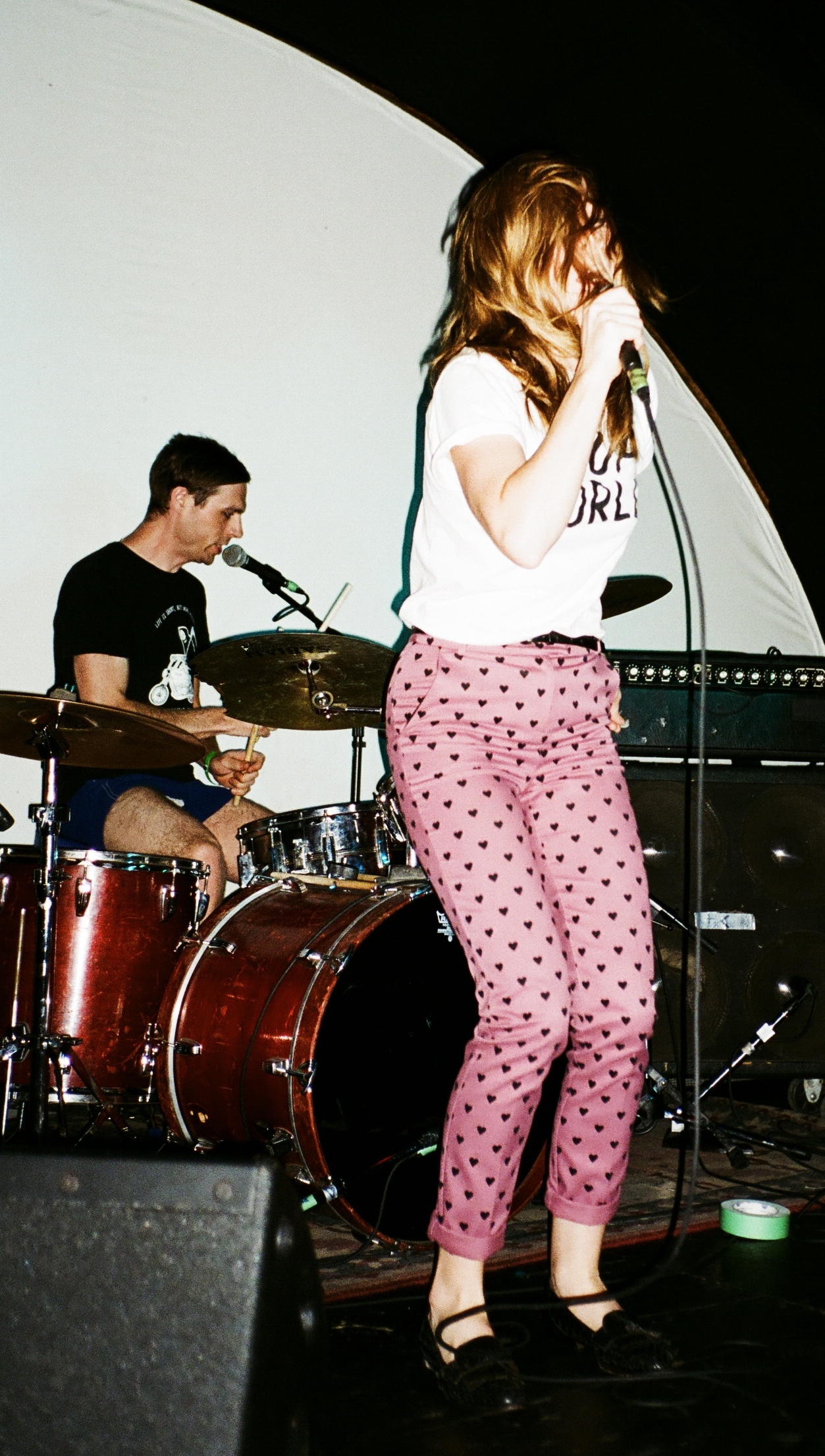 a woman on stage with a microphone, and a band in the background