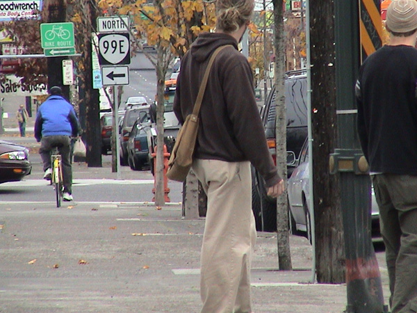 a man walking down a street while holding onto a bag