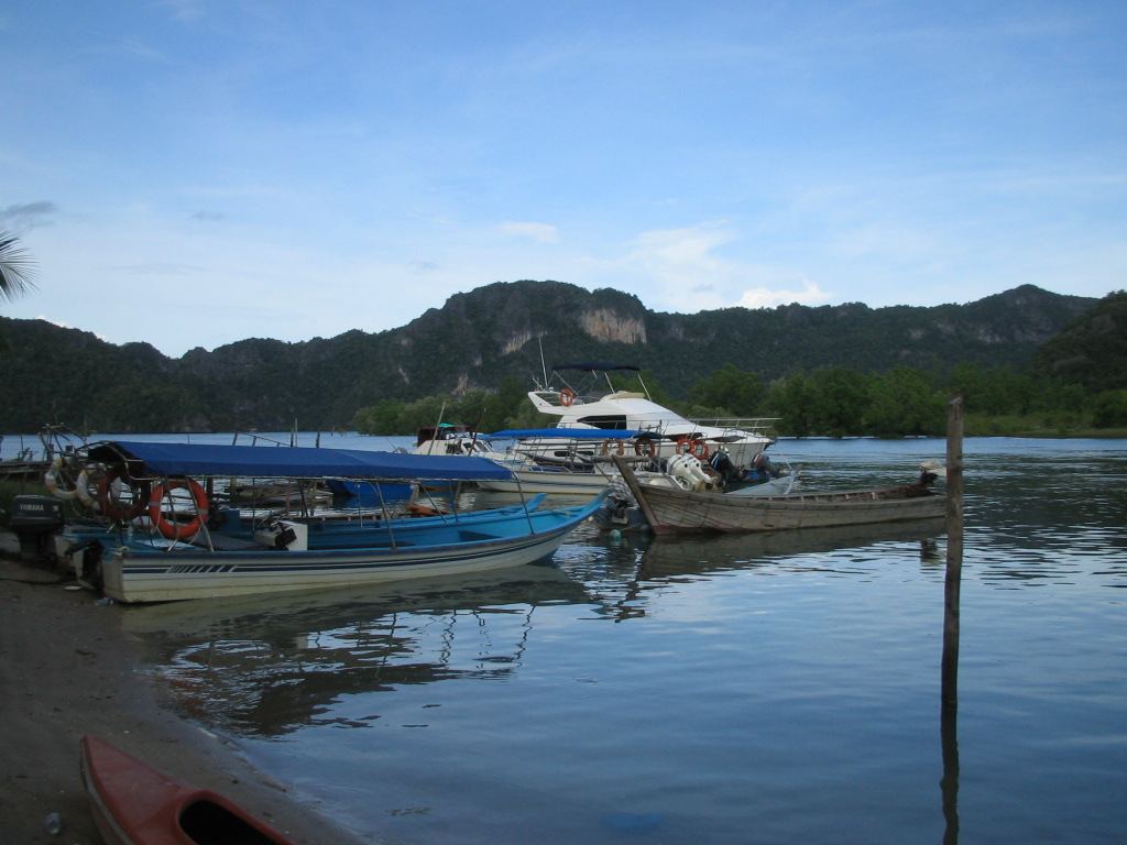 the boats are docked next to the water and mountains